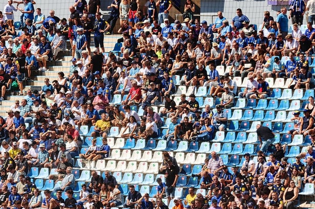 Personas ocupando lso asientos de un estadio