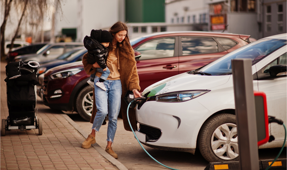 Mujer con bebé cargando vehículo eléctrico